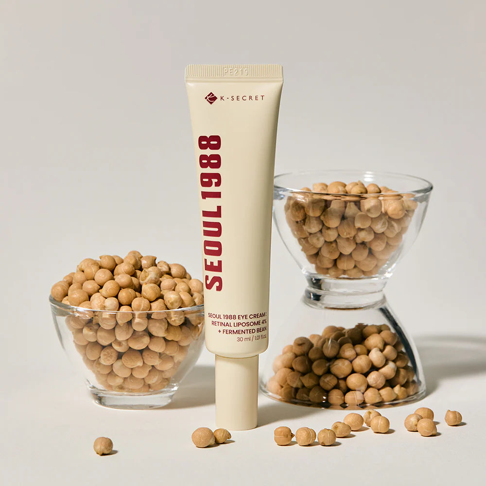 Tube of K-Secret Seoul 1988 skincare product with soybeans on a light background