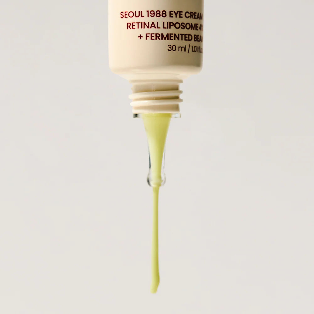 Skincare dropper with yellow liquid and visible brand text on a light gray background