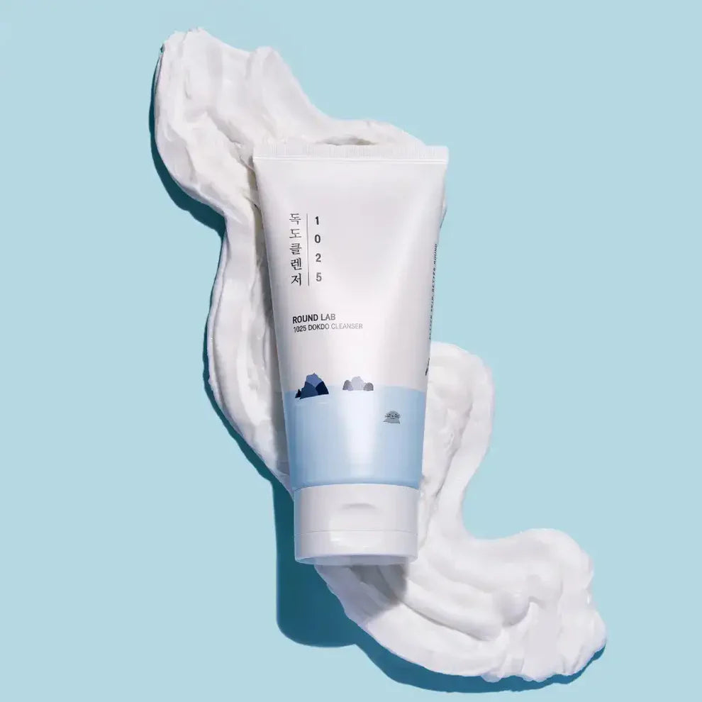 Tube of cream with white foam on a light blue background