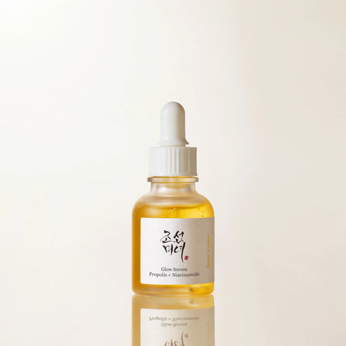 Skincare serum bottle with dropper on a light beige background