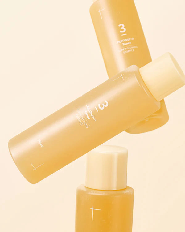 Three yellow bottles with white caps on a beige background