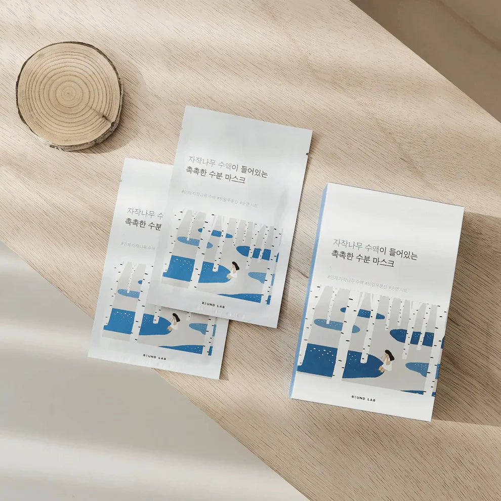 Three sheets of paper with blue and white designs on a wooden surface
