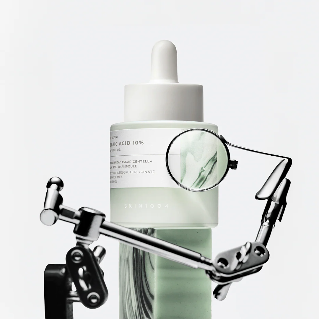 Skincare dropper bottle with a magnifying glass on a white background