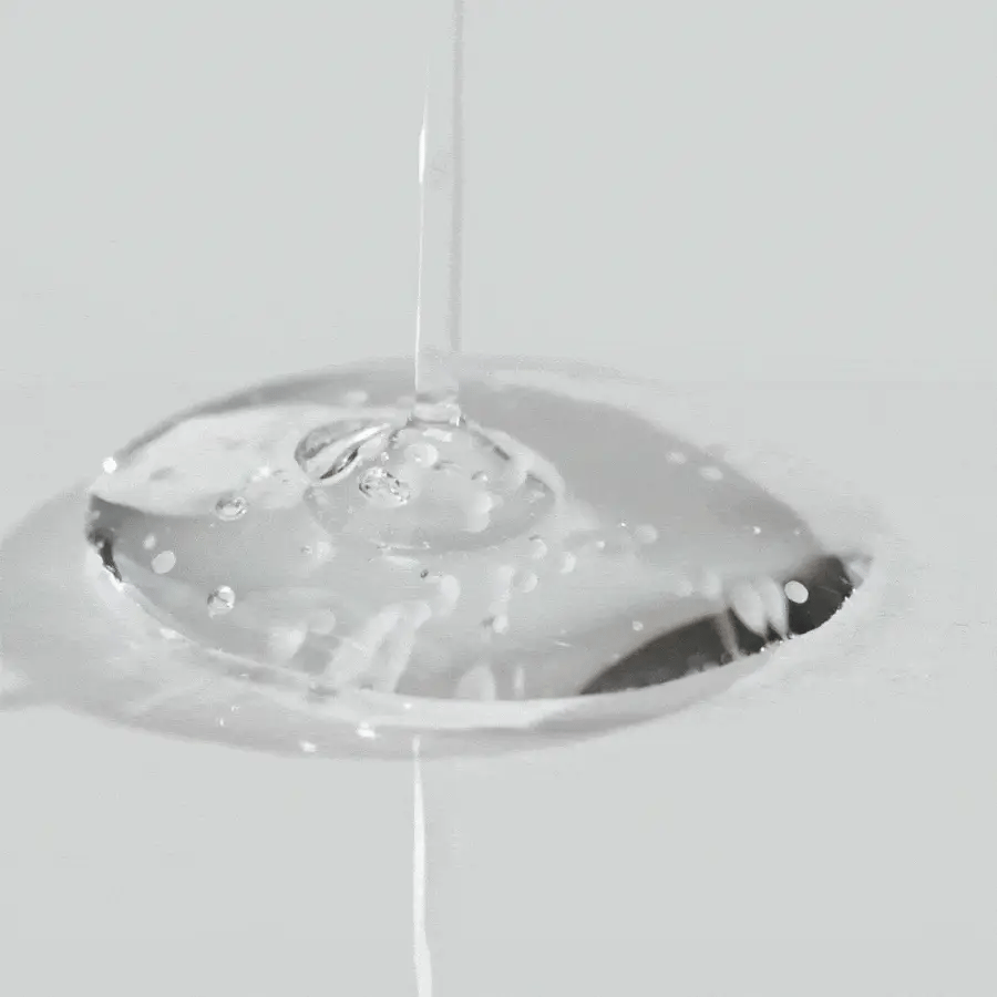 Close-up of a clear liquid droplet on a white background